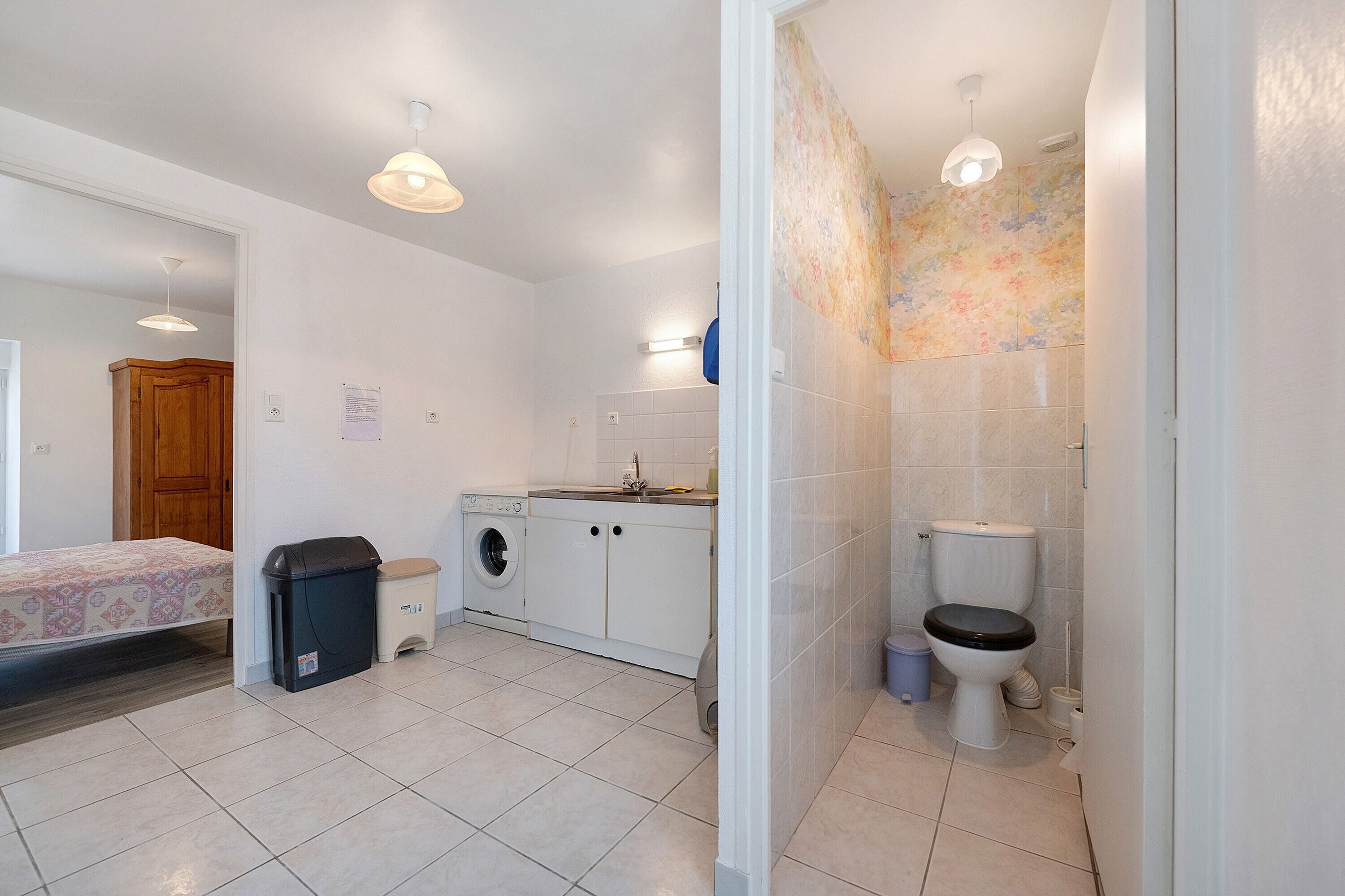 Ein kleines Badezimmer mit Toilette, Waschbecken und Waschmaschine.