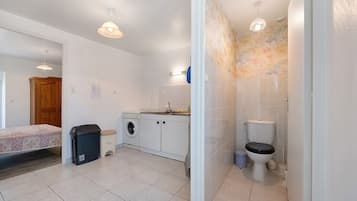 Ein kleines Badezimmer mit Toilette, Waschbecken und Waschmaschine.