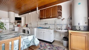 A compact kitchen with a built-in oven, a sink, and a water heater. - Guest Room "Chambre 1" with Wi-Fi (Courtils)