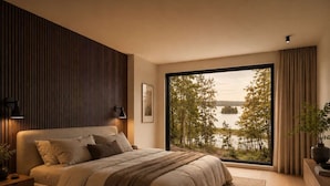 Quarto moderno com uma janela ampla, uma cama com vista para um lago, e um painel de parede de madeira.