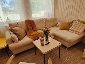 Una sala de estar acogedora con un sofá, una mesa de centro y un florero con flores.