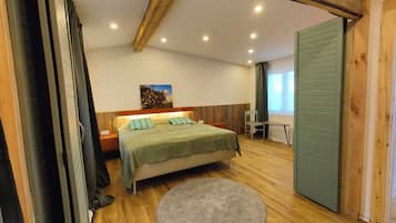 A bedroom with a bed, a desk, a chair, and a round rug.
