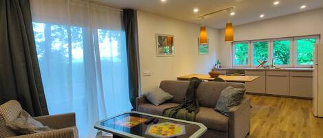 A modern living room with a sofa, armchair, and a glass-top coffee table.