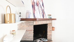 A brick fireplace with a shelf above it holding a painting, a kettle, and a jar. - SE306 - Senigallia, four-room apartment on two levels near the sea and the historic center. (Senigallia)