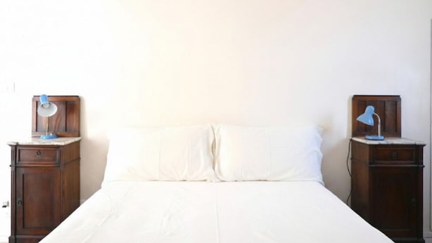 A bed with white bedding, two bedside tables with lamps, and a plain wall. - SE306 - Senigallia, four-room apartment on two levels near the sea and the historic center. (Senigallia)