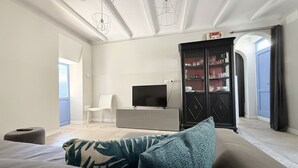 A modern living room with a sofa, a flat-screen TV, a cabinet, and a chair. - SE306 - Senigallia, four-room apartment on two levels near the sea and the historic center. (Senigallia)