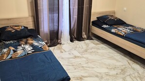 A room with two beds, a wooden headboard, a marble floor, and a window with curtains. - Entire Luxury Home (Chalon-sur-Saône)