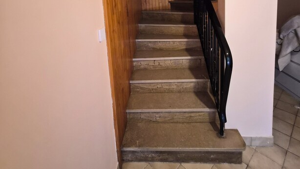 A staircase with wooden walls and a tiled floor leading to a landing. - Entire Luxury Home (Chalon-sur-Saône)