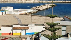 Una propiedad costera con playa, muelle y un edificio con el letrero 'Lido Massimo'.