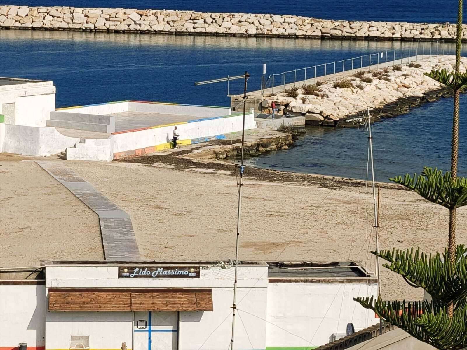Un edificio frente al mar con un letrero que dice 'Lido Massimo'.
