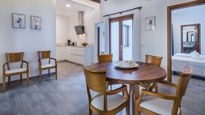 A modern kitchen with white cabinets, a dining table with chairs, and a large window. - Central House With Pool, Puerto Pollenca (Pollença)
