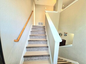 Un escalier avec des rampes en bois et un mur blanc.