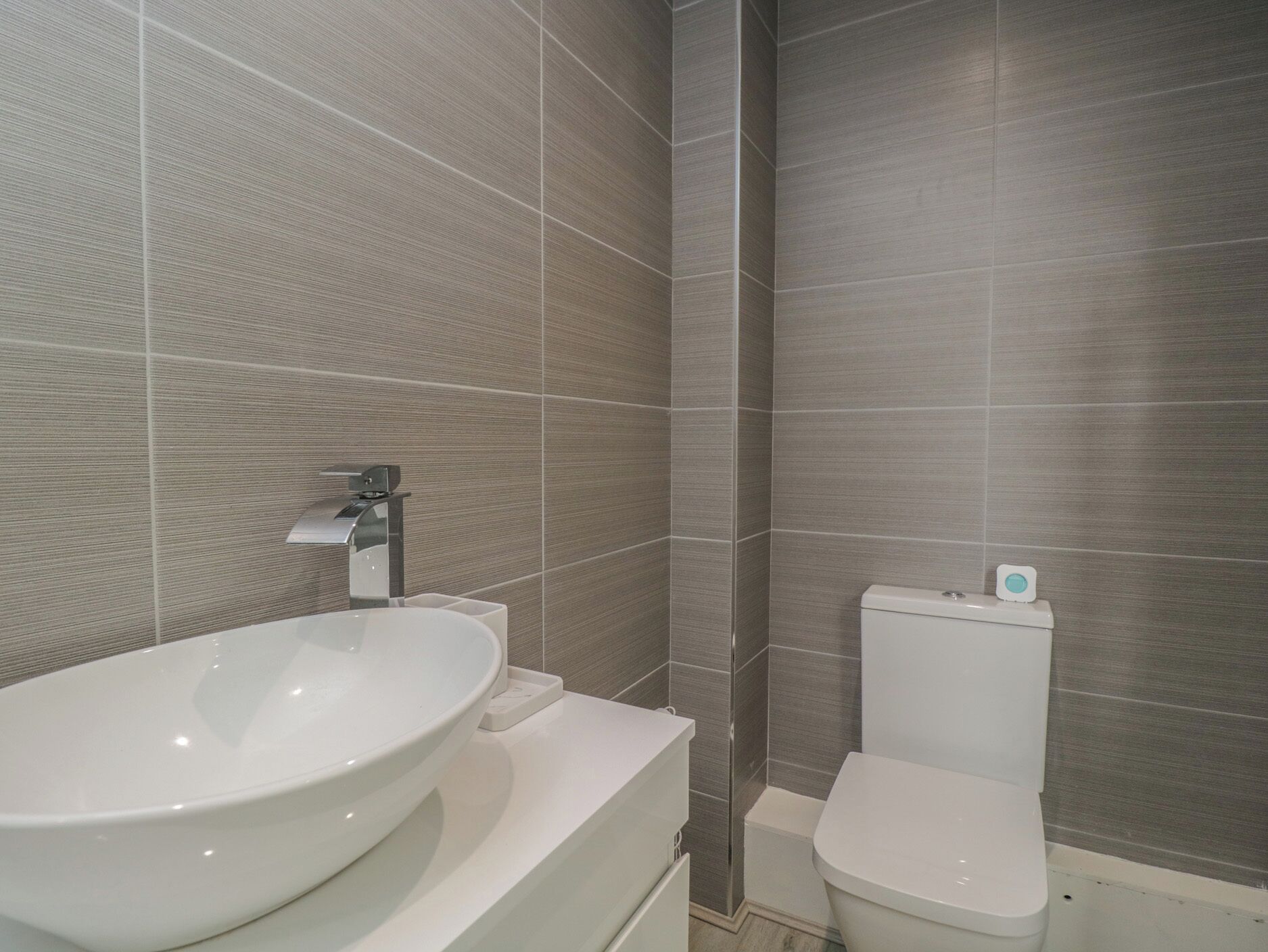 A bathroom with a white sink, a toilet, and a shower area.