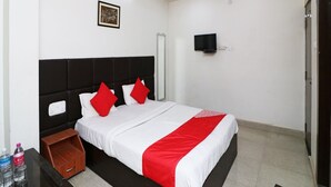 A hotel room with a bed, a ceiling fan, a mounted TV, and a framed picture on the wall. - Townhouse Hatia Railway Station (Ranchi)