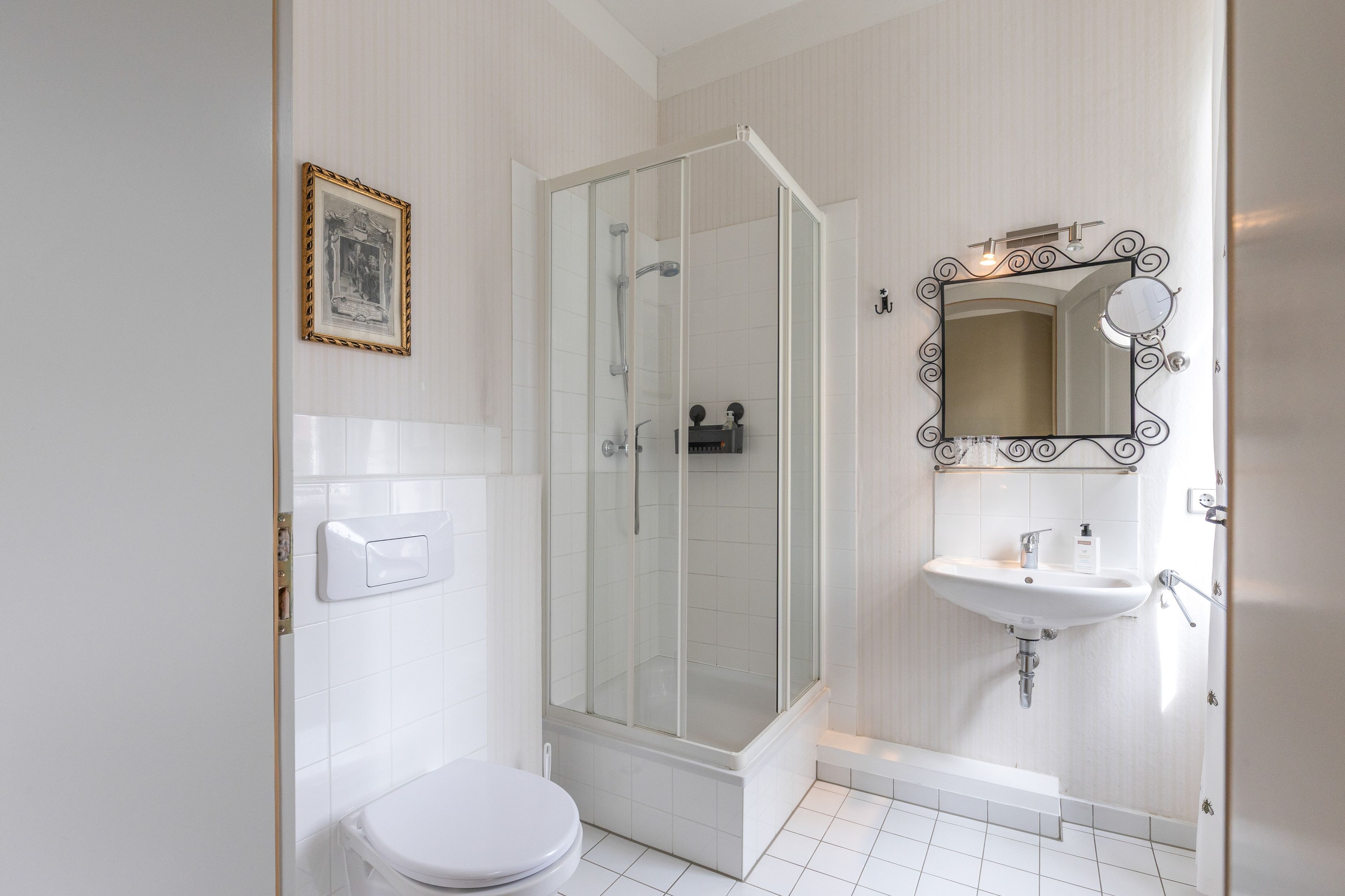 Ein Badezimmer mit Toilette, Duschkabine, Waschbecken und Spiegel.