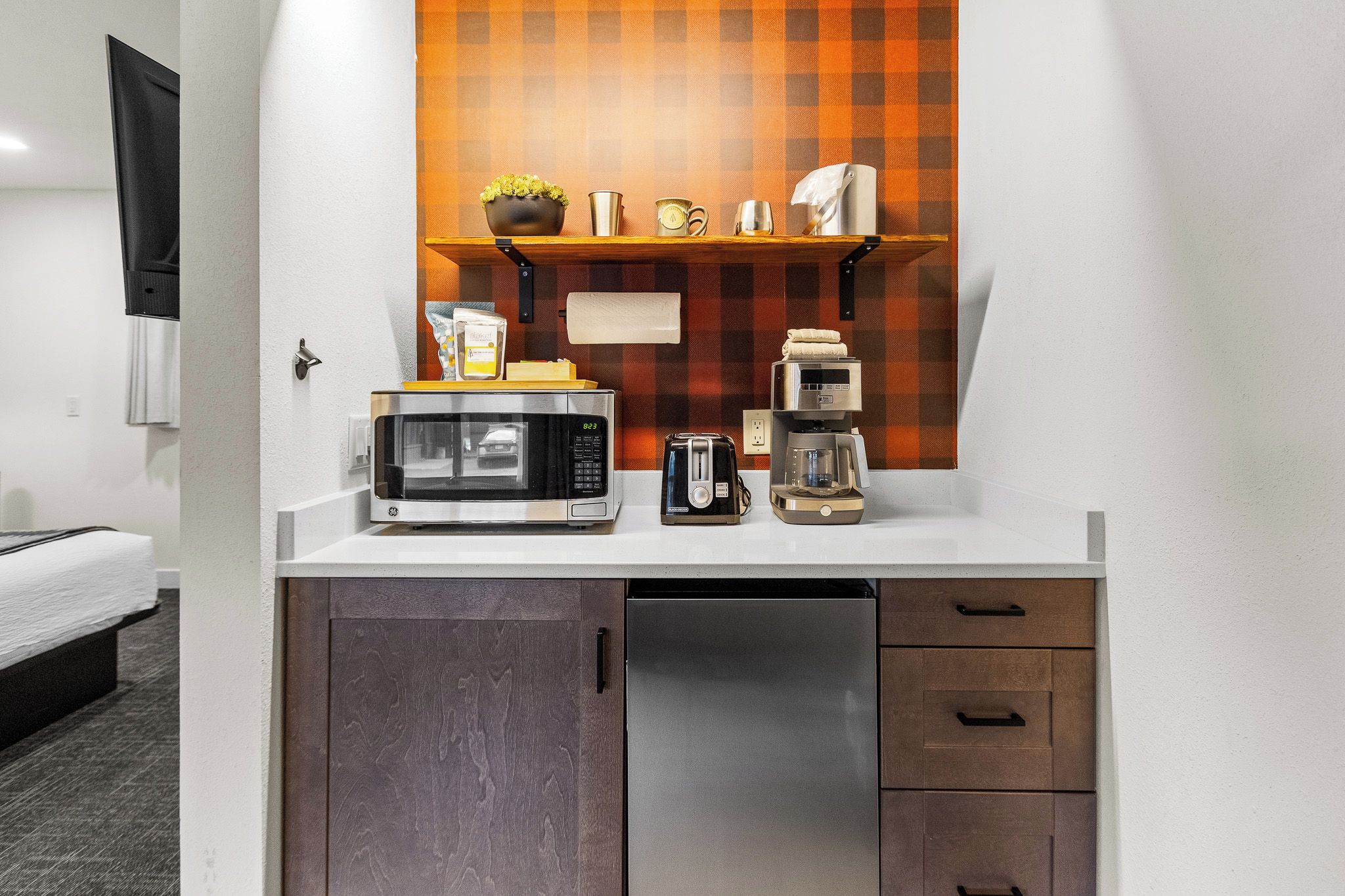 A compact kitchenette with a microwave, toaster, and coffee maker.