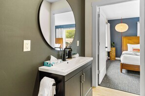 A bathroom with a mirror, sink, and toilet.