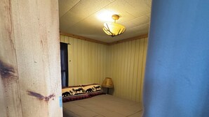 A bedroom with a bed, a lamp, and a ceiling light.