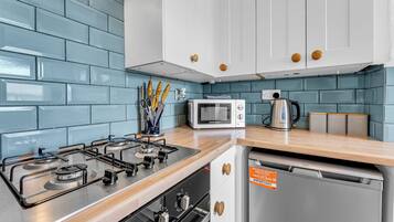 A kitchen with a gas stove, microwave, and a dishwasher.