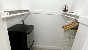 A laundry room with a washing machine, a drying rack, and a utility shelf. - Shine Suites Balcony Studio (Miami)