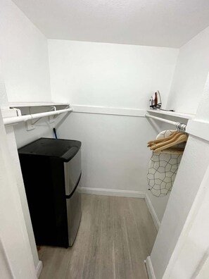 A laundry room with a washing machine, a drying rack, and a utility shelf. - Shine Suites Balcony Studio (Miami)