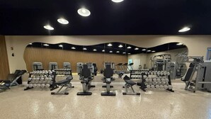 A gym with various exercise equipment, including dumbbells and weight machines. - Shine Suites Balcony Duplex (Miami Beach)
