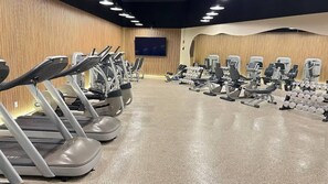 A gym with treadmills, elliptical machines, and weight equipment. - Shine Suites Balcony Duplex (Miami Beach)