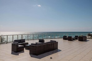 A terrace with outdoor seating and a view of the sea. - Shine Suites Balcony Duplex (Miami Beach)