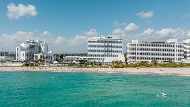 A coastal cityscape with high-rise hotels, a beach, and clear turquoise waters. - Shine Suites Balcony Duplex (Miami Beach)