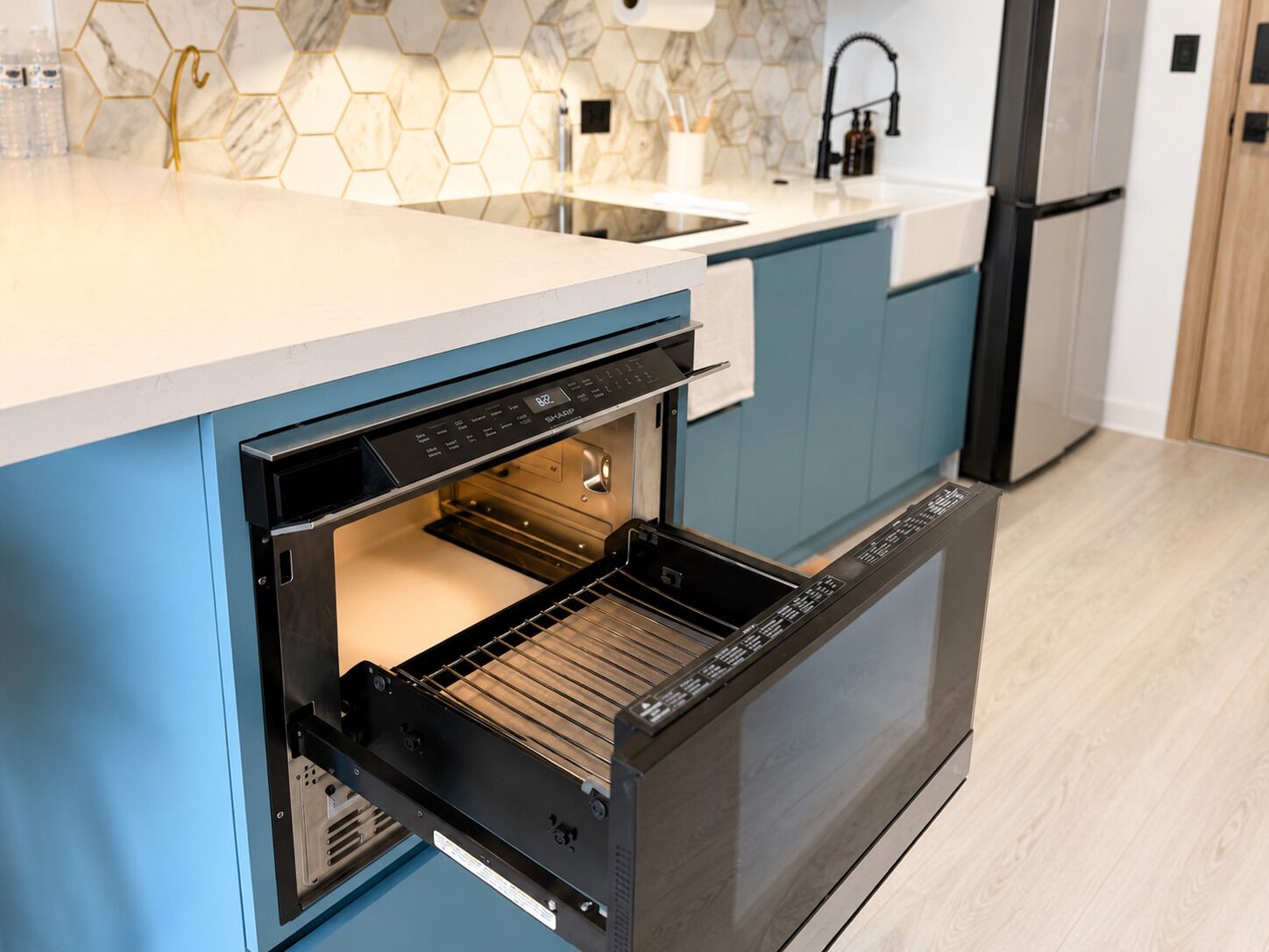 Eine Küche mit Einbauofen, Spüle und Kühlschrank.
