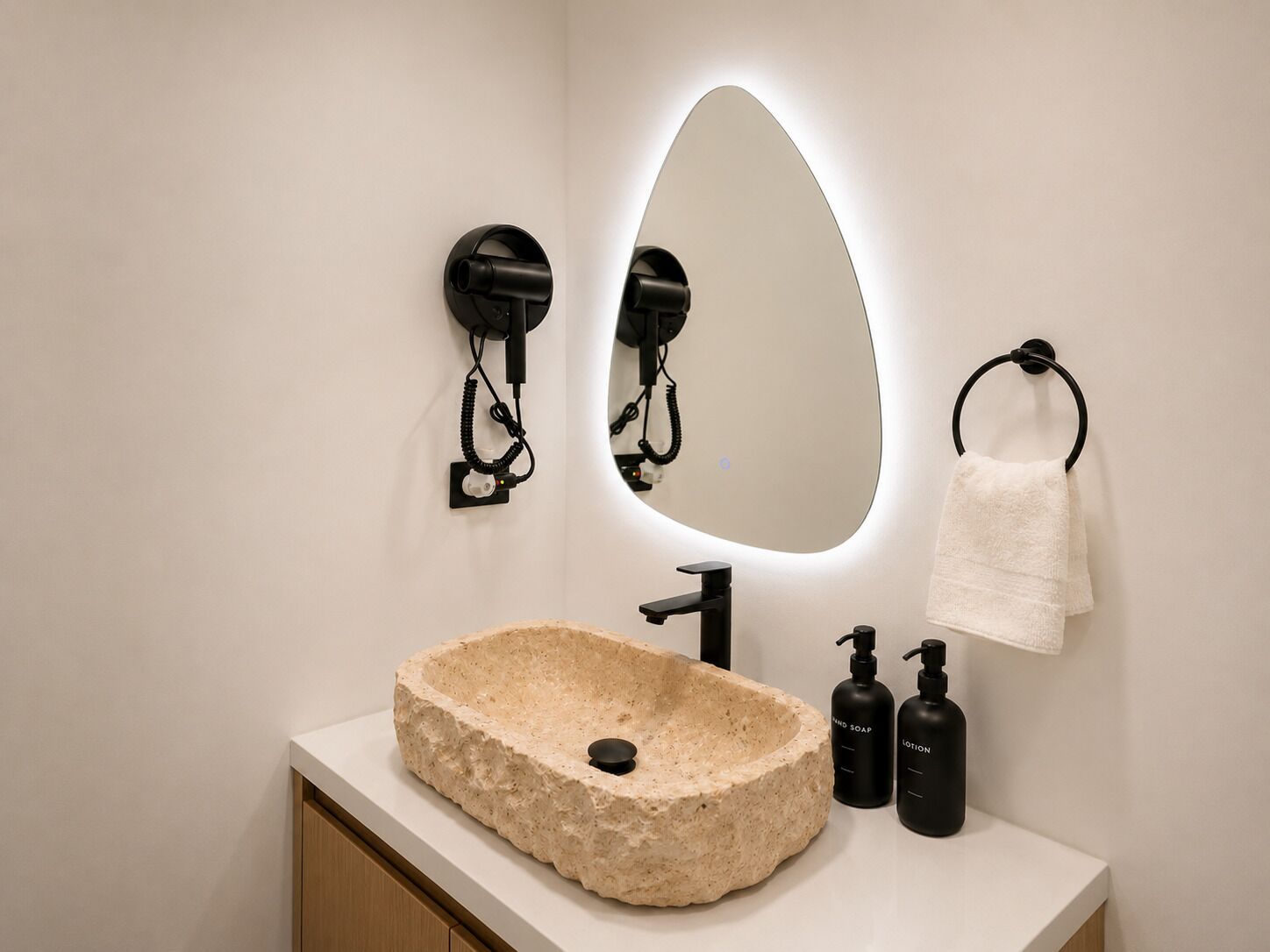Ein Badezimmer mit einem Steintonne, einem Spiegel, einem Handtuchhalter und zwei Seifenspendern.