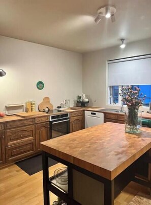A kitchen with wooden cabinets, a central island, and a window with a view.