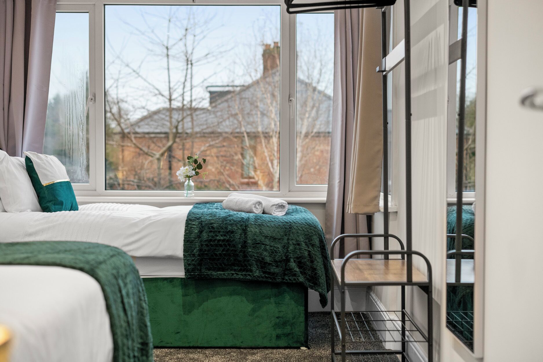 Une chambre à coucher avec un lit, une fenêtre, une chaise et une petite table.