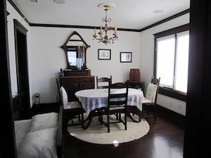 A dining room with a round table, chairs, a chandelier, a mirror, and framed pictures on the wall. - Charming 2-bedroom cottage steps to the Strand Hermosa Beach (Hermosa Beach)