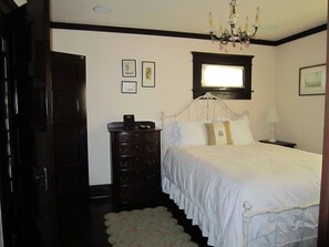 A bedroom with a bed, dresser, and a chandelier. - Charming 2-bedroom cottage steps to the Strand Hermosa Beach (Hermosa Beach)