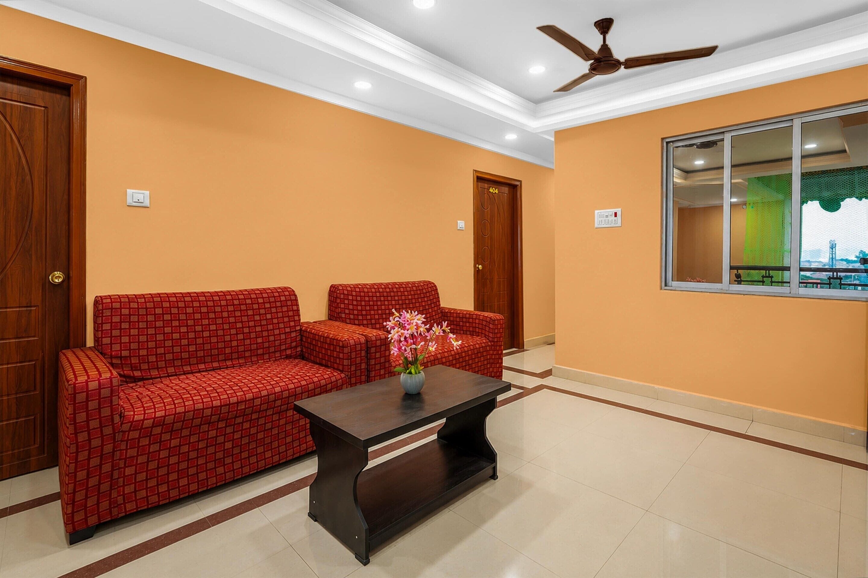 A room with a sofa set, a coffee table, and a ceiling fan.