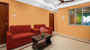 A room with a sofa set, a coffee table, and a ceiling fan.