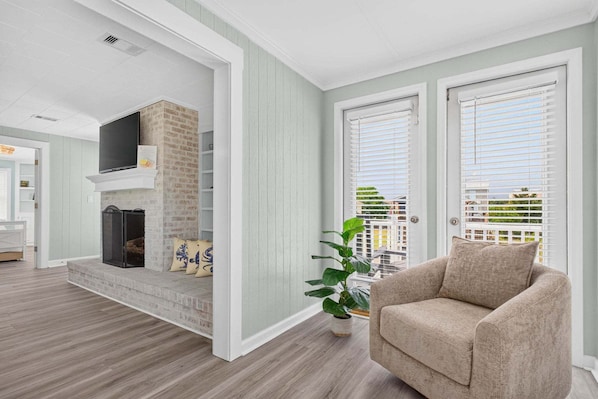A living room with a fireplace, a television, and a sofa. - Sea Monkeys Beach Cottage: 3BR, 2BA retreat in Holden Beach. (Holden Beach)