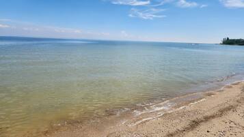A beach with clear water and a sandy shore.