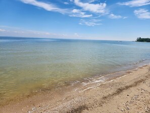 A beach with clear water and a sandy shore.