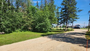 A gravel driveway leading to a residential area with houses and a playground. - Modern Rustic Cabin in Balaton Beach with Lake Access & Firepit (Balaton Beach)