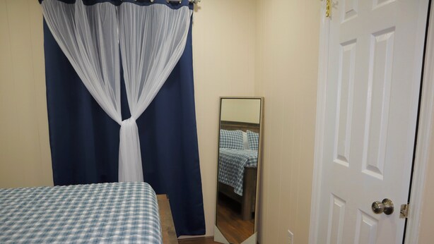 Een slaapkamer met een bed, een spiegel en een deur.