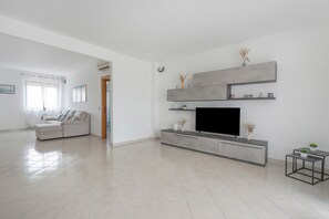 A modern living room with a flat-screen TV, a sofa, and a coffee table. - Apartment 'Casa Di Anna' with Balcony, Wi-Fi and Air Conditioning (Polignano a Mare)