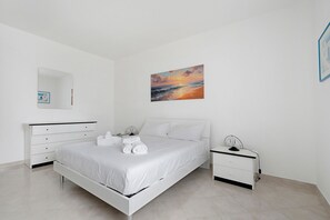 Um quarto moderno com uma cama, uma mesa de cabeceira, um espelho e um quadro na parede.