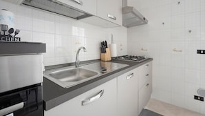 Et moderne køkken med stålemmer, en dobbeltvask og en gasblus.