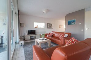 A modern living room with a sofa set, a flat-screen TV, and a coffee table. - Coastal Bungalow With Private Garden (Makkum)