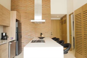 A modern kitchen with a central island, a gas stove, and a stainless steel refrigerator. - Alluring New Apt w/ private Rooftop/Old city (Cartagena de Indias)