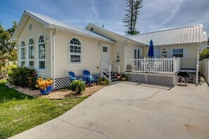 A two-story house with a porch, a covered patio, and a fenced yard. - 214 Pearl Main Pet Friendly Cottage near Beach (Fort Myers Beach)