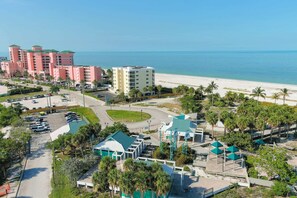A coastal hotel with multiple buildings, a parking lot, and a beach view. - Vacation Villas #432 - Beachfront Condo (Fort Myers Beach)