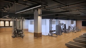 A gym with exercise equipment, wooden floors, and a modern design.